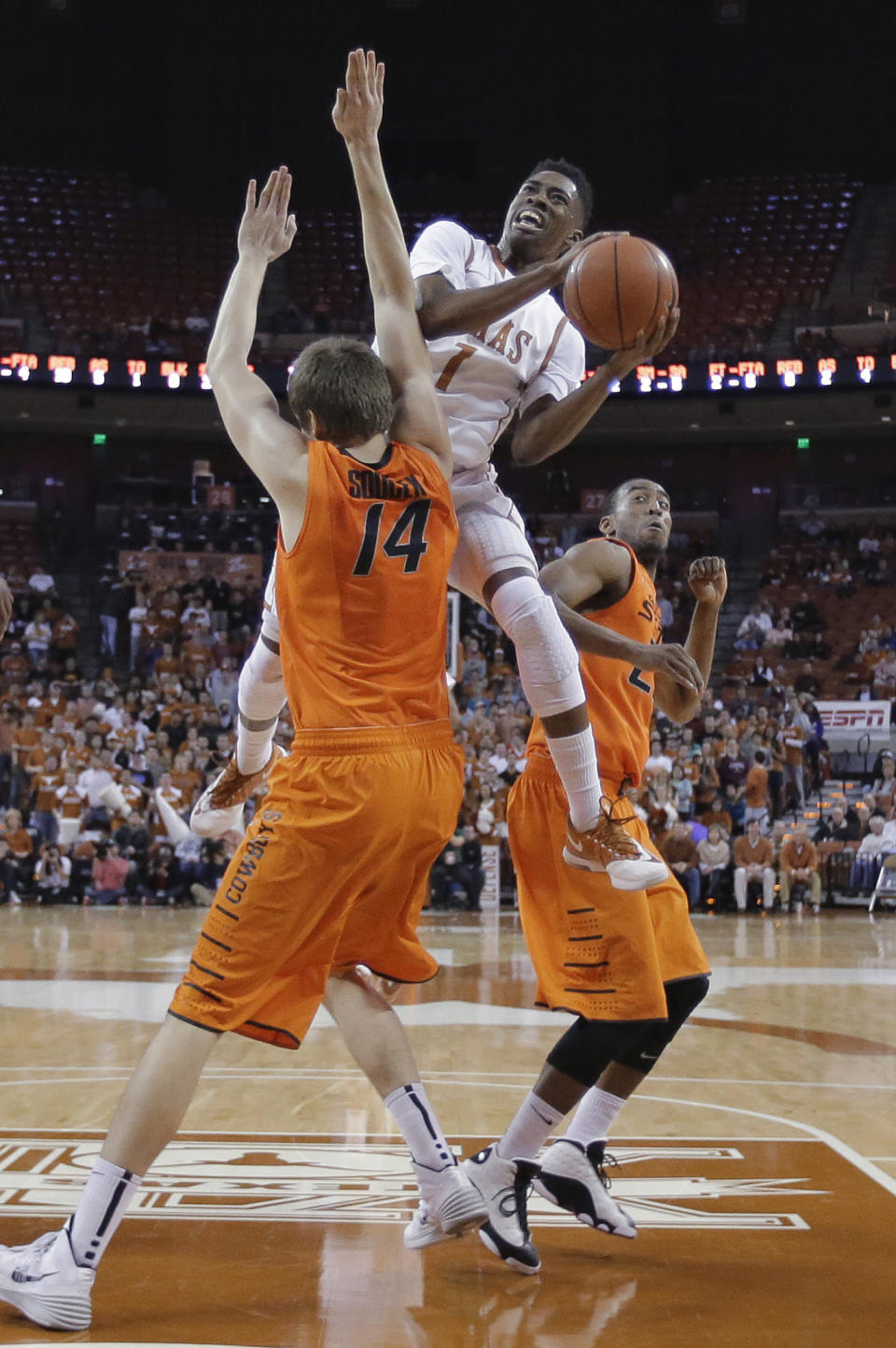 Texas' Isaiah Taylor (1) crashes into Oklahoma State's Marek Soucek (14) as he drives to the basket during the first half on an NCAA college basketball game, Tuesday, Feb. 11, 2014, in Austin, Texas. (AP Photo/Eric Gay)