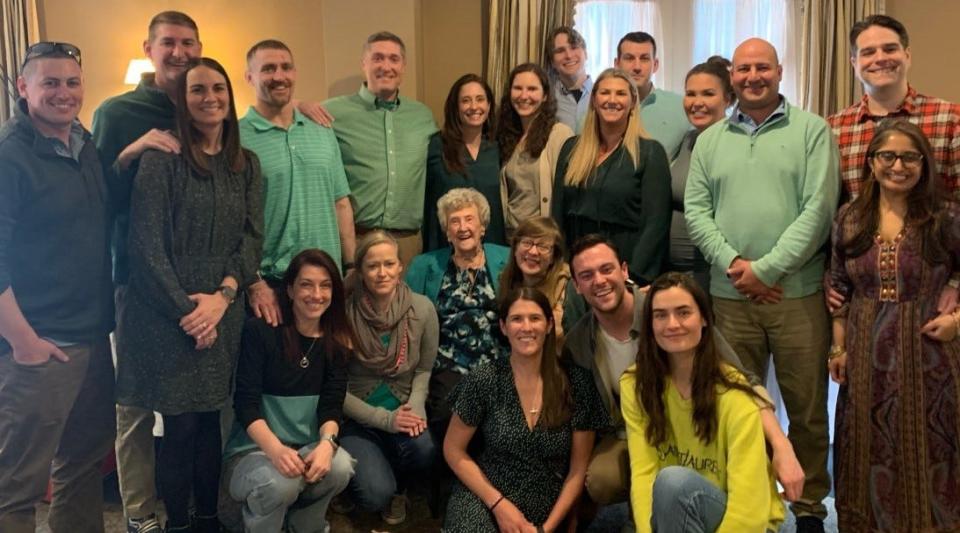 Mary Warren, of Weymouth, seated in the center front, with her 12 grandchildren and their spouses at her 100th birthday party March 18, 2023, at The Common Market in Quincy.