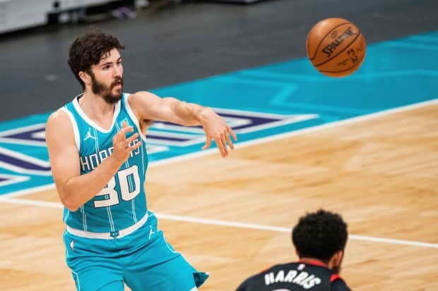 Charlotte Hornets guard Nate Darling passes the ball against the Toronto Raptors during the second half of an NBA basketball game in Charlotte, N.C., on Saturday. Darling became the first Nova Scotian to play in the NBA regular season. (AP Photo/Jacob Kupferman - image credit)