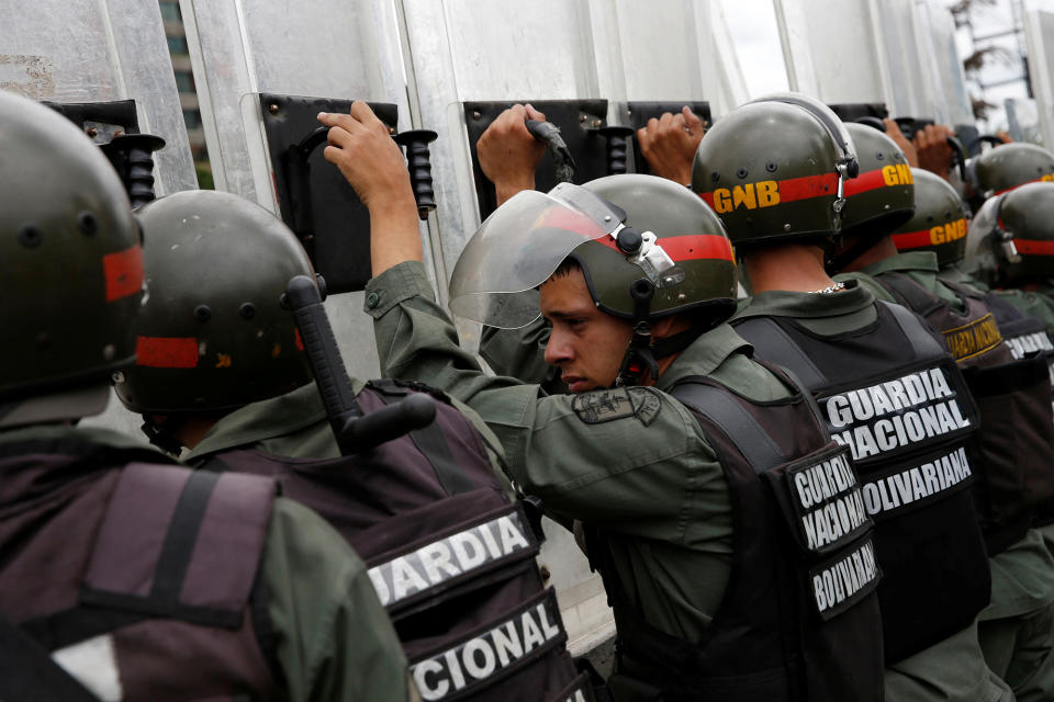 <p>Venezuelan National Guards take cover behind their shields as they recover from tear gas, in Caracas, Venezuela, June 7, 2016. (Reuters/Carlos Garcia Rawlins) </p>