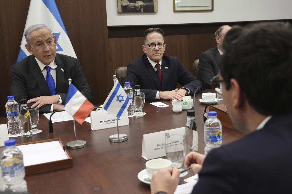 Israeli Prime Minister Benjamin Netanyahu, left, meets with France's Foreign Minister Stephane Sejourne, right foreground, during their meeting in Jerusalem Monday, Feb. 5, 2024. 5, 2024. (Gil Cohen-Magen/Pool via AP)