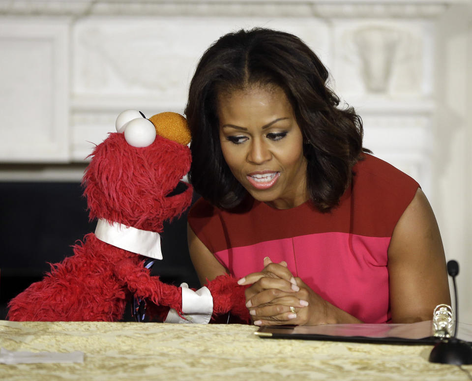 First lady Michelle Obama listens to PBS Sesame Street's character Elmo during an event to help promote fresh fruit and vegetable consumption in the State Dining Room of the White House in Washington, Wednesday, Oct. 30, 2013. Sesame Workshop and the Produce Marketing Association (PMA) joined in Partnership for a Healthier America (PHA) in announcing a 2-year agreement to making healthy choices by using the Sesame Street characters to help deliver the messages about fresh fruits and vegetables. (AP Photo/Pablo Martinez Monsivais)