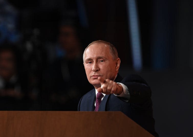 Vladimir Putin pointing directly at the camera.