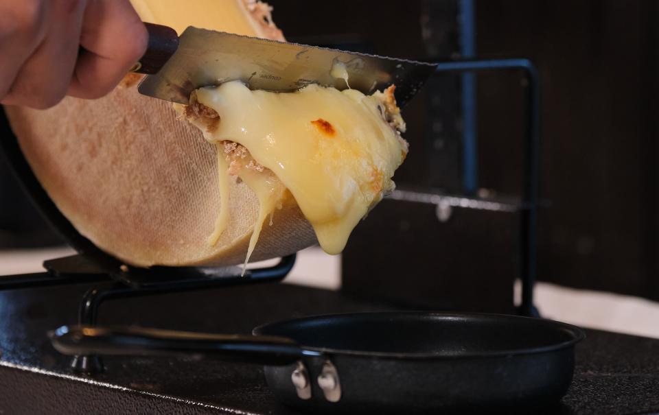 Raclette cheese is melted, then scraped for topping meats and veggies at Pistache French bistro in West Palm Beach.