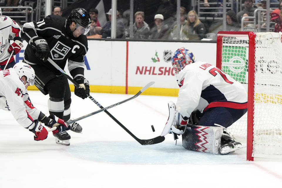 Los Angeles Kings center Anze Kopitar, center, tries to get a shot pas Washington Capitals goaltender Charlie Lindgren, right, as left wing Beck Malenstyn defends during the second period of an NHL hockey game Wednesday, Nov. 29, 2023, in Los Angeles. (AP Photo/Mark J. Terrill)