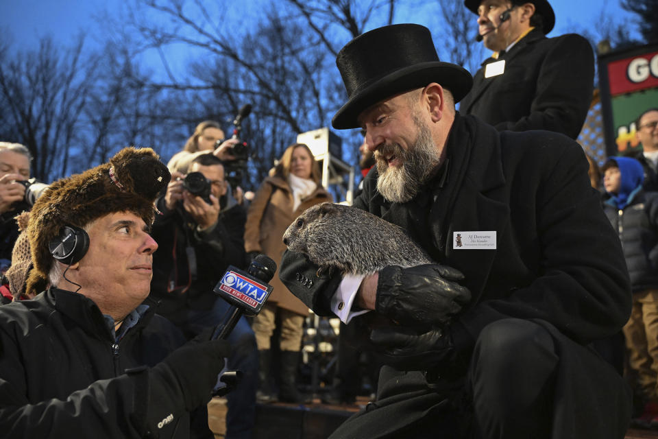 Groundhog Club handler A.J. Dereume holds Punxsutawney Phil, the weather prognosticating groundhog, as he is interviewed by a reporter during the 138th celebration of Groundhog Day on Gobbler's Knob in Punxsutawney, Pa., Friday, Feb. 2, 2024. Phil's handlers said that the groundhog has forecast an early spring. (AP Photo/Barry Reeger)