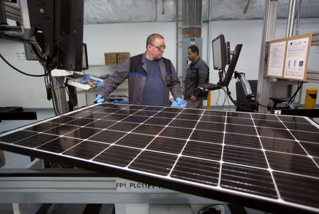 Production operator John White checks a panel at the SolarWorld solar panel factory in Hillsboro, Oregon, U.S., January 15, 2018. Picture taken January 15, 2018. REUTERS/Natalie Behring