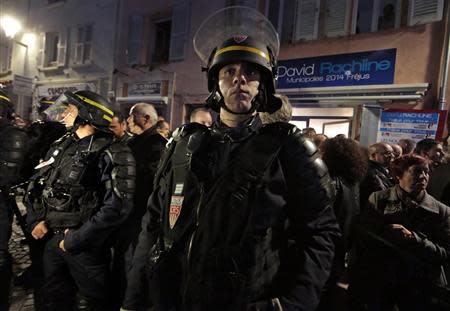 French riot policemen stand guard in front of the campaign headquarters of David Rachline, France's far-right National Front political party member head of the list for municipal elections, after Rachline won in the second round in the French mayoral elections in Frejus March 30, 2014. REUTERS/Eric Gaillard