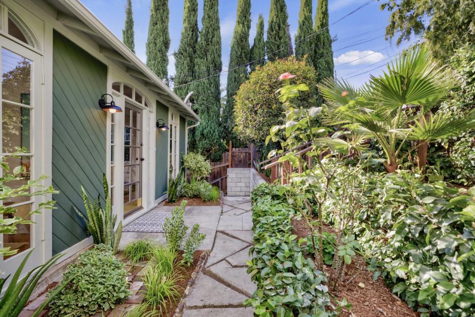 Tucked away from the street, this historic residence has graceful archways, a chic black kitchen, and a backyard oasis.