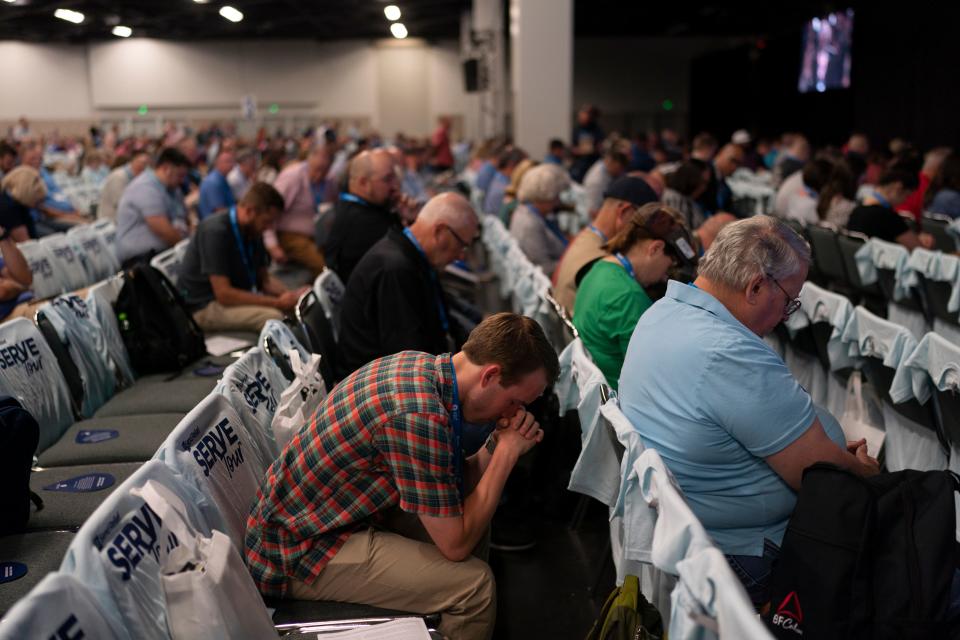 Attendees pray Tuesday during a worship service at the Southern Baptist Convention's annual meeting in Anaheim, Calif.