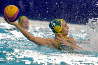 Australia's Bronte Halligan (4) protects the ball from a defender during a preliminary round women's water polo match against Canada at the 2020 Summer Olympics, Saturday, July 24, 2021, in Tokyo, Japan. (AP Photo/Mark Humphrey)