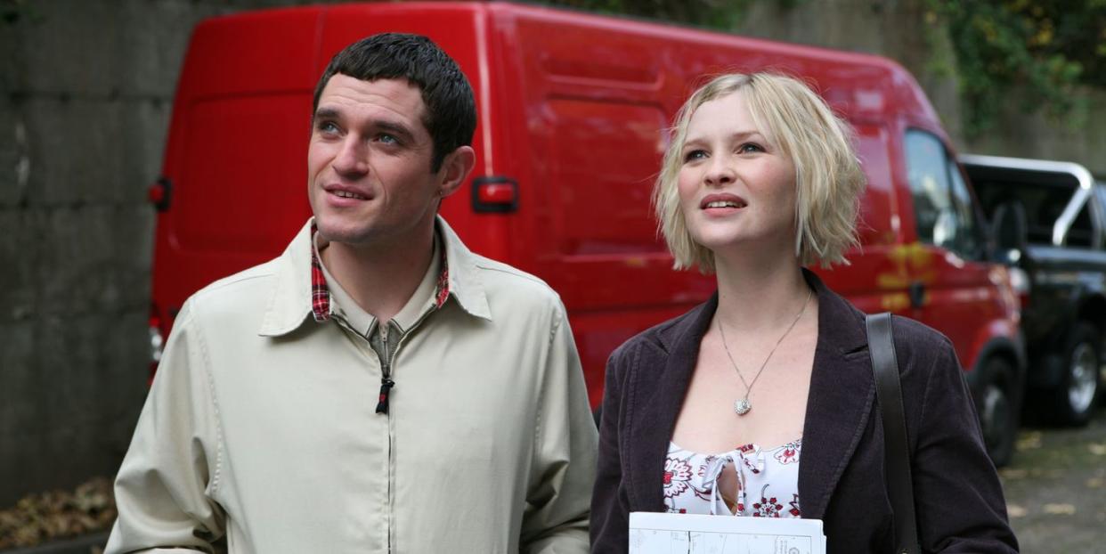 a man and woman standing next to each other and looking at the camera