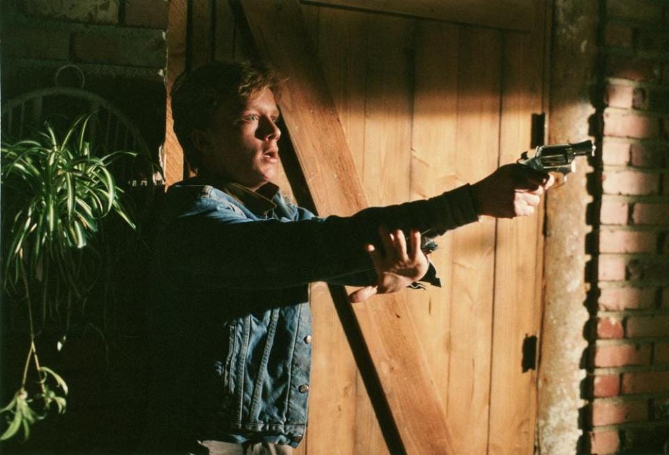 Anthony Michael Hall holding a gun