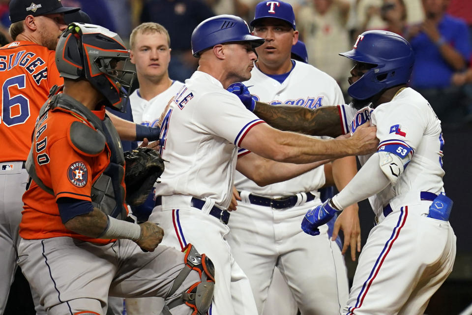 Texas Rangers' Corey Ragsdale, center, gets between Adolis Garcia (53) and Houston Astros catcher Martin Maldonado after Garcia was hit by a pitch during the eighth inning in Game 5 of the baseball American League Championship Series Friday, Oct. 20, 2023, in Arlington, Texas. (AP Photo/Julio Cortez)