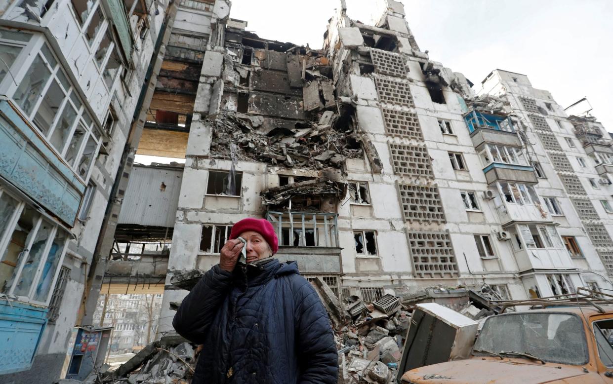 A local elderly resident cries next to her apartment building in Mariupol which was destroyed by shelling - ALEXANDER ERMOCHENKO 