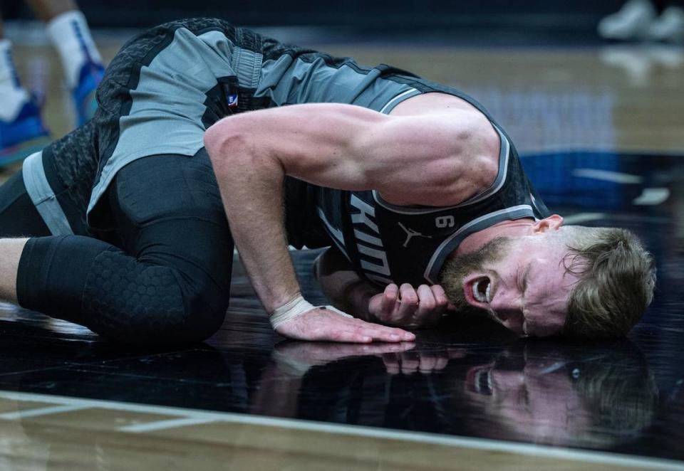 Sacramento Kings center Domantas Sabonis (10) lies on the floor in pain after he was stepped on by Golden State Warriors forward Draymond Green (23) during Game 2 of the first-round NBA playoff series at Golden 1 Center on Monday.