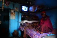 A former leprosy sufferer watches television in a leprosy colony in New Delhi