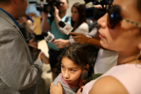 Estela Juarez, 9, hugs her mother Alejandra Juarez (R), who is deported to Mexico from the Orlando International Airport in Orlando, Florida, U.S., August 3, 2018. REUTERS/Joey Roulette