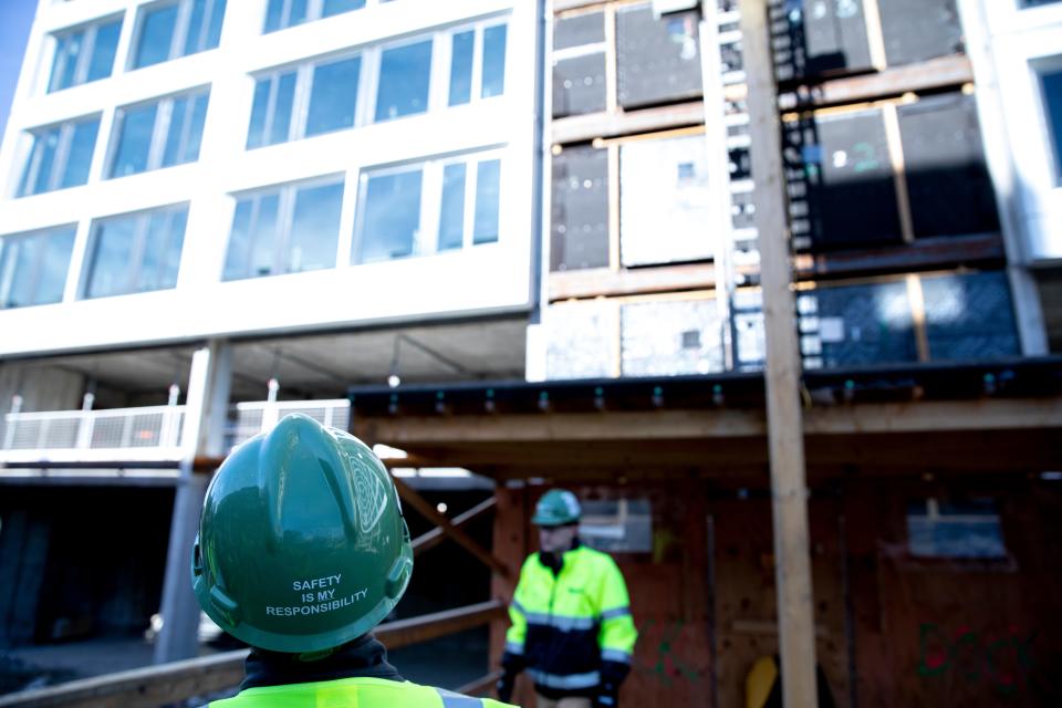 Tyler Wirth, a University of Cincinnati sophomore, who works as a project engineer for Messer Construction through the UC cooperative program, looks up at a construction site before doing a safety inspection at the University of Cincinnati campus on Tuesday, Nov. 16, 2021. Wirth is in his second co-op work semester at UC. Wirth's duties at Messer include making safety checks of a construction site.