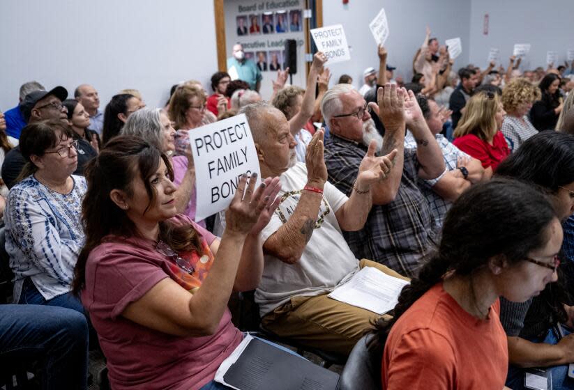 MURRIETA, CA - AUGUST 10, 2023: Attendees in support of the parental notification policy hold up signs stating "Protect Family Values" during a school board meeting which decided 3-2 to enact a policy which would notify parents if any child identifies as transgender on August 10, 2023 in Murrieta, CA. (Gina Ferazzi / Los Angeles Times)