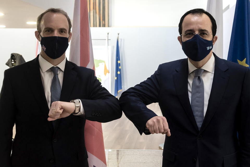 Cypriot Foreign Minister Nicos Christodoulides, right, and Britain's Secretary of State for Foreign Affairs, Dominic Raab, clad due before their meeting at the foreign house in capital Nicosia, Cyprus, Thursday, Feb. 4, 2021. Raab is in Cyprus for one day of talks (Iakovos Hatzistavrou Pool via AP)