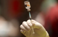 A health worker prepares for a shot of Sinovac's COVID-19 vaccine during a mass vaccination for traders and workers at a shopping mall in Tangerang, Indonesia, Monday, March 1, 2021. (AP Photo/Tatan Syuflana)