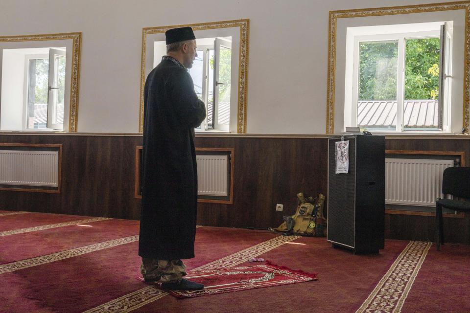 Former Mufti-turned-fighter Sheikh Said Ismahilov leads Muslim soldiers during prayers on the first day of Eid al-Adha, in Medina Mosque, Konstantinovka, eastern Ukraine, Saturday, July 9, 2022. Muslims around the world celebrate Eid al-Adha by sacrificing animals to commemorate the prophet Ibrahim's faith in being willing to sacrifice his son. (AP Photo/Nariman El-Mofty)