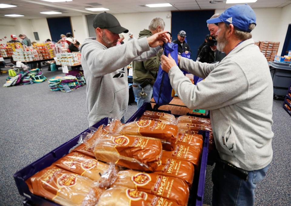 School employees from left, Jason Fortner and Robert Hardy load perishable food Into bags to be distributed. The Winter Tiger Bites event featured members of the Frenship staff, Willow Bend Elementary School, members of the Rotary Club of Lubbock, and Betenbough volunteers who filled more than 500 backpacks with food that will be delivered to families needing extra help this Christmas.