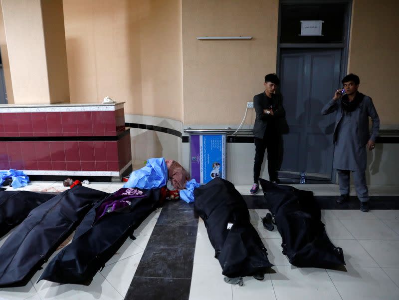 Afghan men look for their relatives at a hospital after a suicide bombing in Kabul