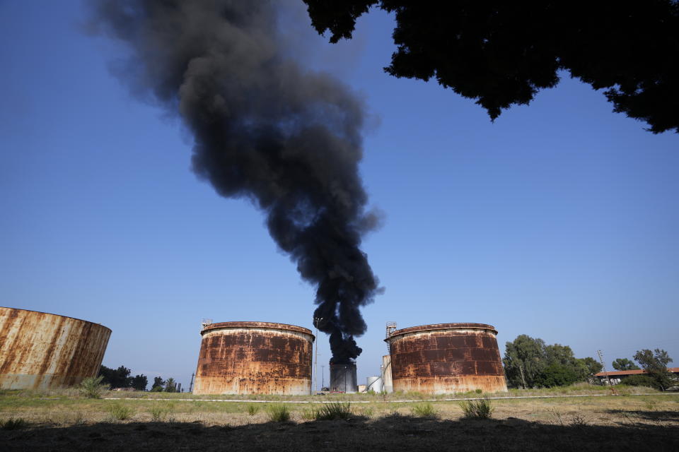 Firefighters work to extinguish a fire in an oil facility in the southern town of Zahrani, south of the port city of Sidon, Lebanon, Monday, Oct. 11, 2021. A huge fire broke out at an oil facility in southern Lebanon's coastal town of Zahrani, but the cause was not immediately known. (AP Photo/Hassan Ammar)