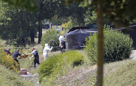 French crime scene investigators, Gendarmes and rescue forces are seen at work next to a black plastic sheet outside a gas company site at the industrial area of Saint-Quentin-Fallavier, near Lyon, France, June 26, 2015. REUTERS/Emmanuel Foudrot