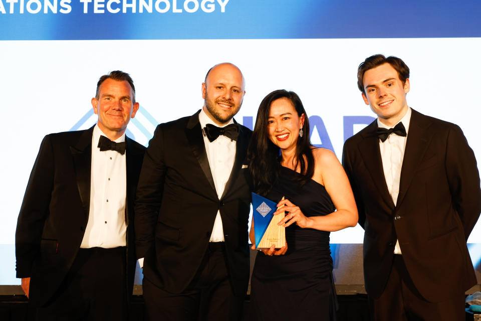 Intapp's Chris Webb and Issy Briault accept the 2024 Drawdown Award for Investor Relations Technology from Jonathon Whiteley, CEO of Real Deals Media and host of the event, Rhys James.