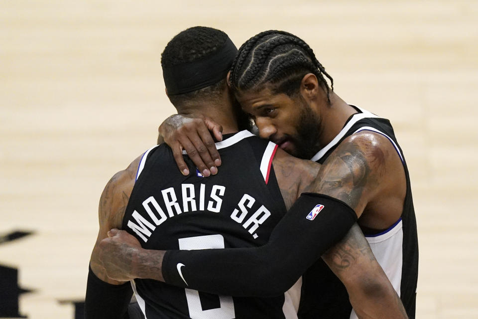 Los Angeles Clippers guard Paul George, right, hugs forward Marcus Morris Sr. during a timeout in the second half of Game 3 of a second-round NBA basketball playoff series against the Utah Jazz Saturday, June 12, 2021, in Los Angeles. (AP Photo/Mark J. Terrill)