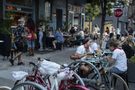 Clientes conviven en la acera del restaurante Dudley's en Nueva York, 22 de junio de 2020. (AP Foto/John Minchillo)