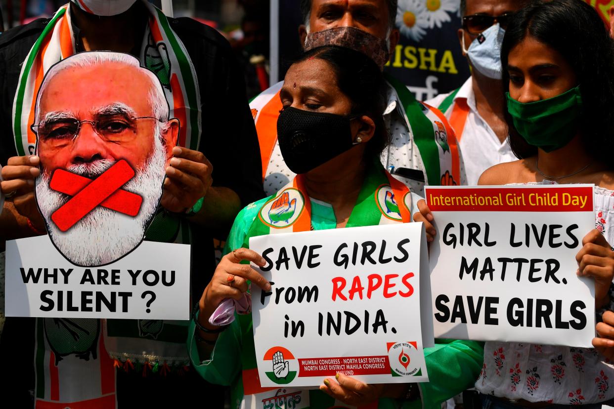 File: Political activists hold placards and a cut-out of India’s prime minister Narendra Modi during a protest condemning the alleged gang-rape and murder of a teenaged woman at Hathras in Uttar Pradesh state (AFP via Getty Images)