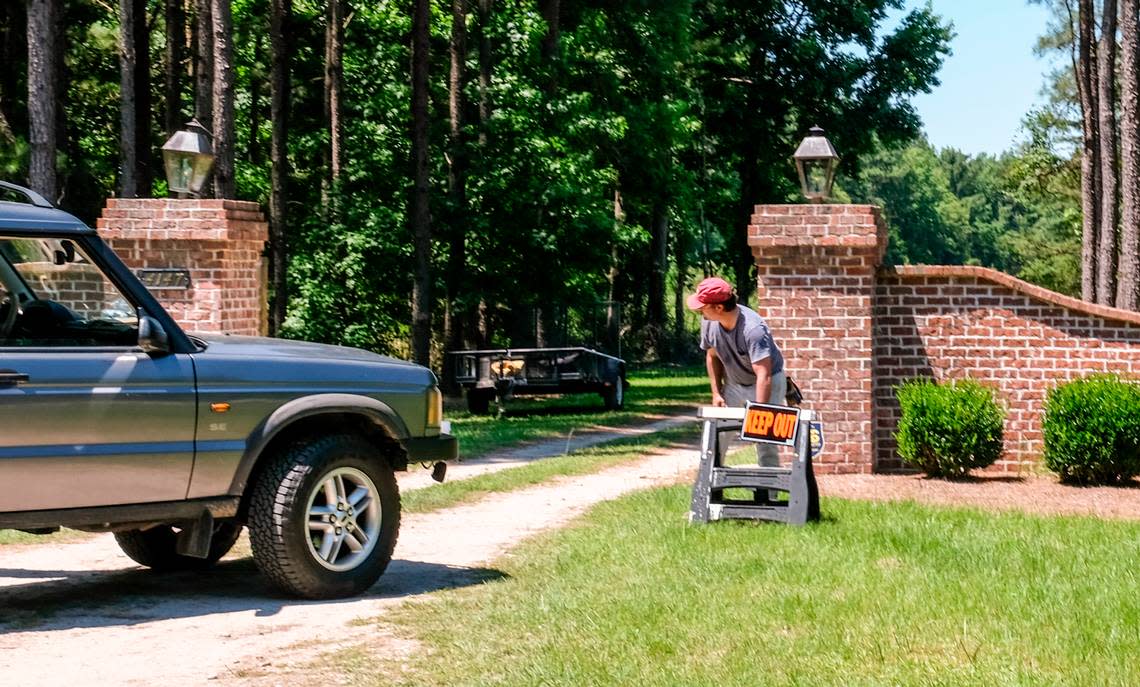 A worker places a “keep out” sign at the entrance to the main house to the Murdaugh property on Thursday, June 17, 2021 on Moselle Road in Islandton, S.C. On Monday, June 7, 2021, Maggie Murdaugh, 52, and her son Paul Murdaugh, 22, died from gunshot wounds in an apparent homicide in at their residence in Colleton County.