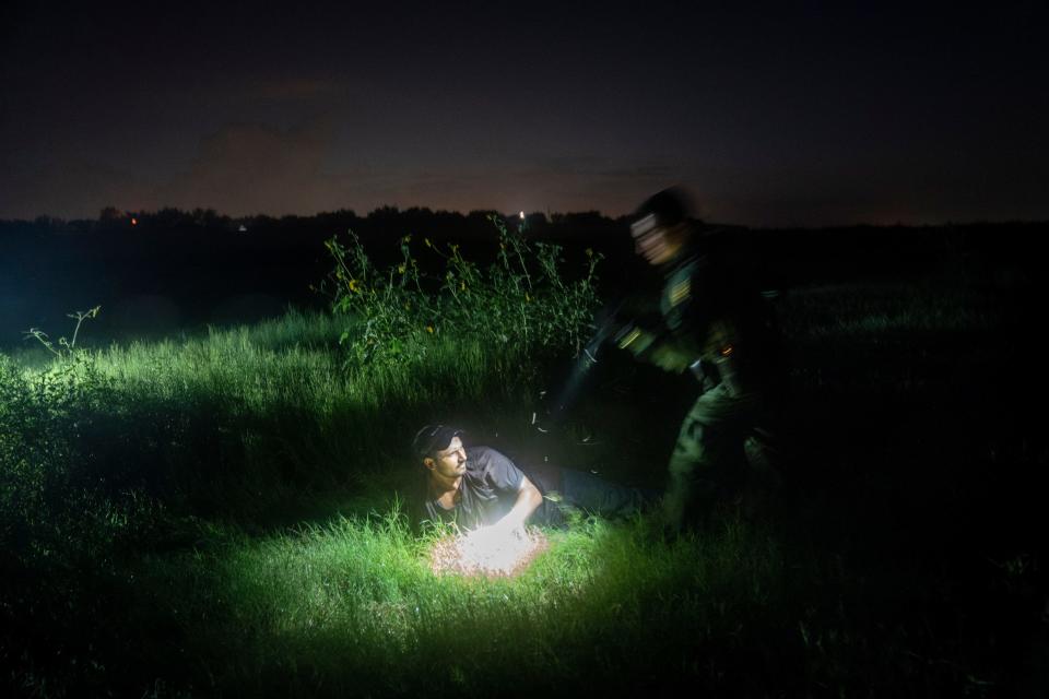 Border Patrol Agent Jesse Moreno, right, helps fellow agents detain three men suspected of illegally crossing into the USA in the wetlands along the U.S.-Mexican border near Granjeno, Texas, on July 13. The agents detained two men from Mexico and one from Honduras.