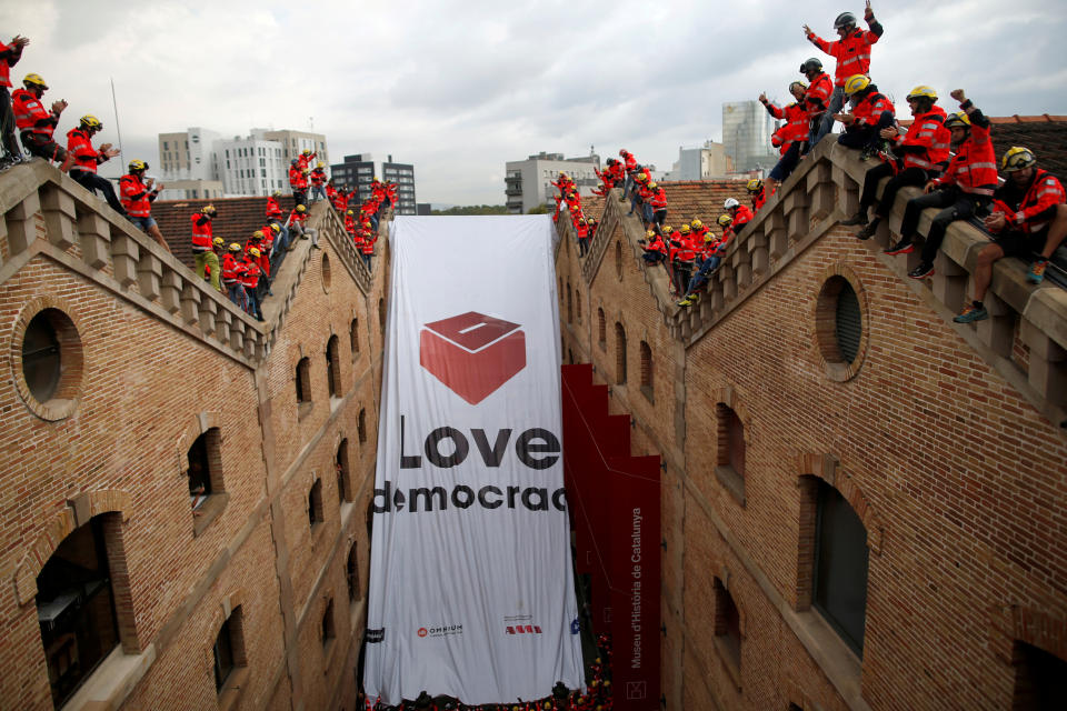 <p>Firemen react as they hang a huge banner in favour of the banned October 1 independence referendum at the Catalonia’s History Museum in Barcelona, Spain Sept. 28, 2017. (Photo: Jon Nazca/Reuters) </p>
