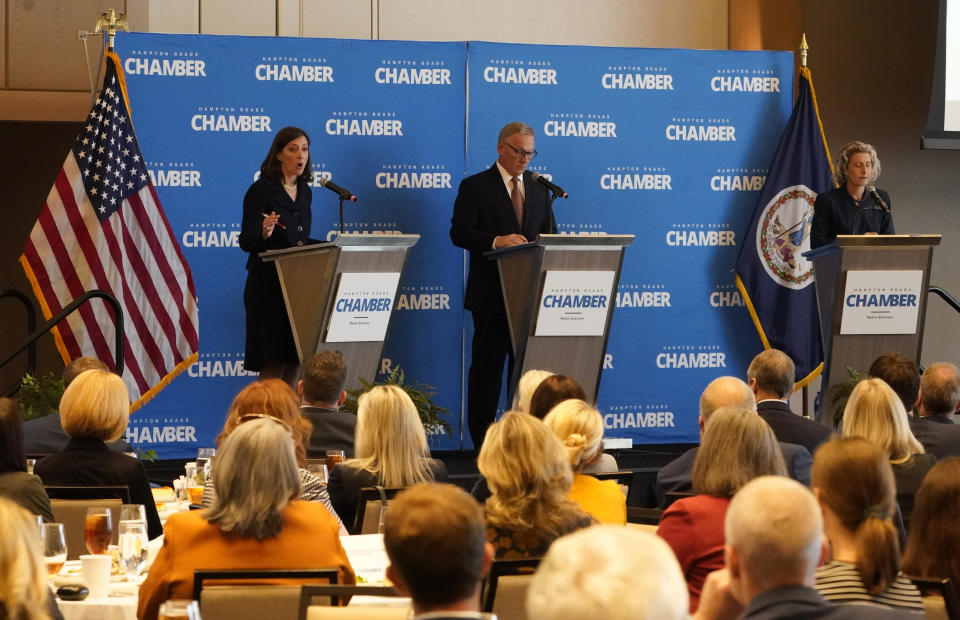 US Rep Elaine Lauria, D-2nd., left, gestures as Republican challenger Virginia State Sen. Jen Kiggans, right, R-Virginia Beach, listens during a debate along with moderator Chris Saxman, center, sponsored by the Hampton roads Chamber of Congress Wednesday, Oct. 12, 2022, in Virginia Beach. Va. (AP Photo/Steve Helber)