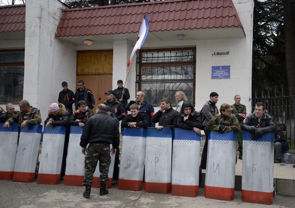 A group of pro-Russia activists with riot shields look on during an anti-war picket in the Crimean city of Simferopol