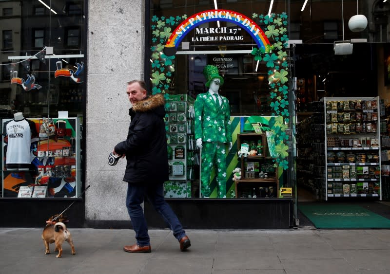 FILE PHOTO: A man walks with his dog on St. Patrick's Day as public events were cancelled due to the number of coronavirus cases grow around the world