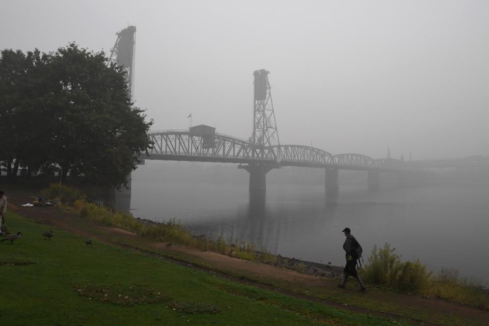 A man walks along the banks of the Williamette River in downtown Portland, Oregon, on September 14, 2020.