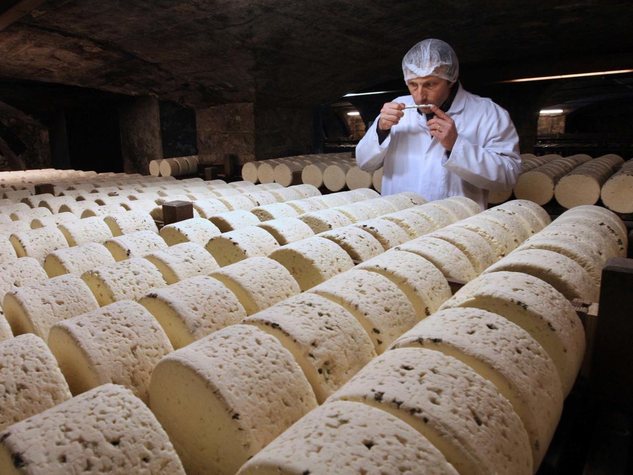A refiner, in a cellar in Roquefort, southwestern France, smells one of the village's eponymous cheeses, which could be hit by new US tariffs: AP