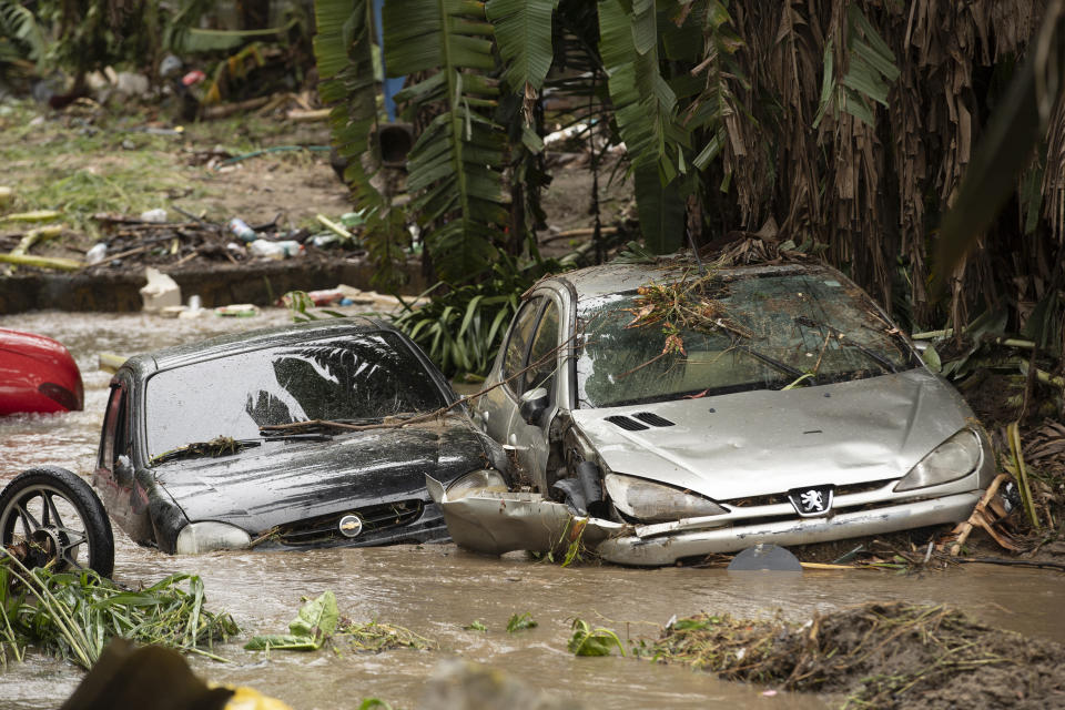 Vehicles that were carried away in flash floods after heavy rains lay in a creek in the Realengo neighborhood of Rio de Janeiro, Brazil, Monday, March 2, 2020. The water flooded the streets and entered homes of residents, with at least 4 deaths reported. (AP Photo/Silvia Izquierdo)