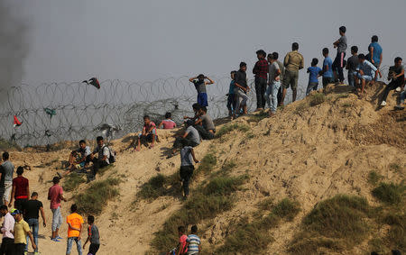 Palestinian protesters gather during clashes with Israeli troops near the border between Israel and central Gaza Strip July 21, 2017. REUTERS/Ibraheem Abu Mustafa