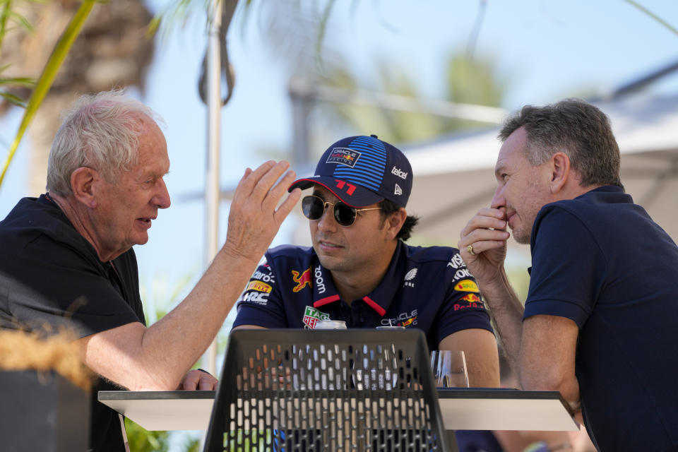 Red Bull team principal Christian Horner, right, chats with Red Bull driver Sergio Perez of Mexico, centre, and Helmut Marko, director of the Red Bull Formula One teams, left, at the pits during Formula One pre season test at the Bahrain International Circuit in Sakhir, Bahrain, Wednesday, Feb. 21, 2024. (AP Photo/Darko Bandic)