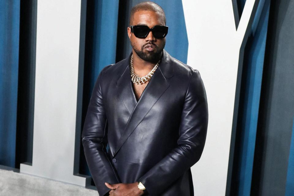 Kanye West wearing a black suit