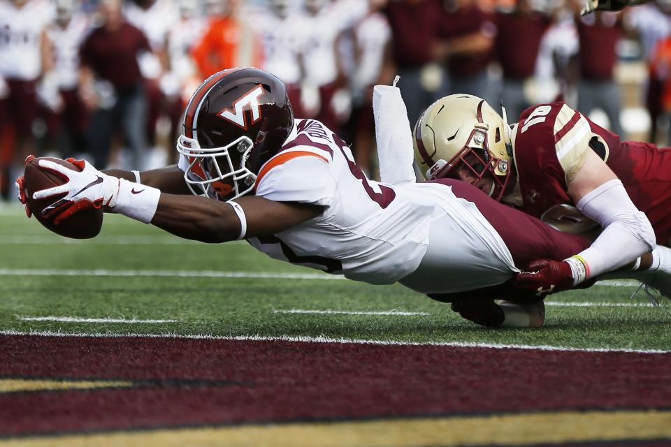 Virginia Tech wide receiver Tayvion Robinson, left, scores against Boston College defensive back Mike Palmer, right, during the first half of an NCAA college football game in Boston, Saturday, Aug. 31, 2019. (AP Photo/Michael Dwyer)