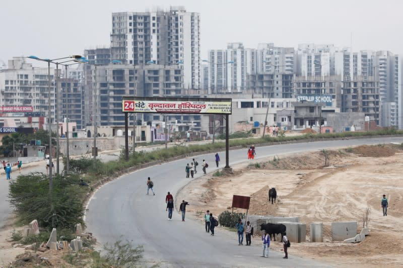 Migrant workers walk on a highway with their families as they look out for a transport to return to their villages, after India ordered a 21-day nationwide lockdown to limit the spreading of coronavirus disease (COVID-19), in Ghaziabad