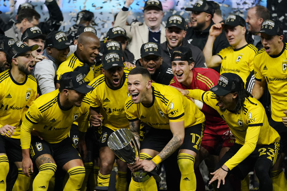 Columbus Crew forward Christian Ramirez (17) holds the trophy as he celebrates with teammates after the MLS Eastern Conference final soccer match against FC Cincinnati, Saturday, Dec. 2, 2023, in Cincinnati. Columbus won 3-2 in overtime. (AP Photo/Carolyn Kaster)